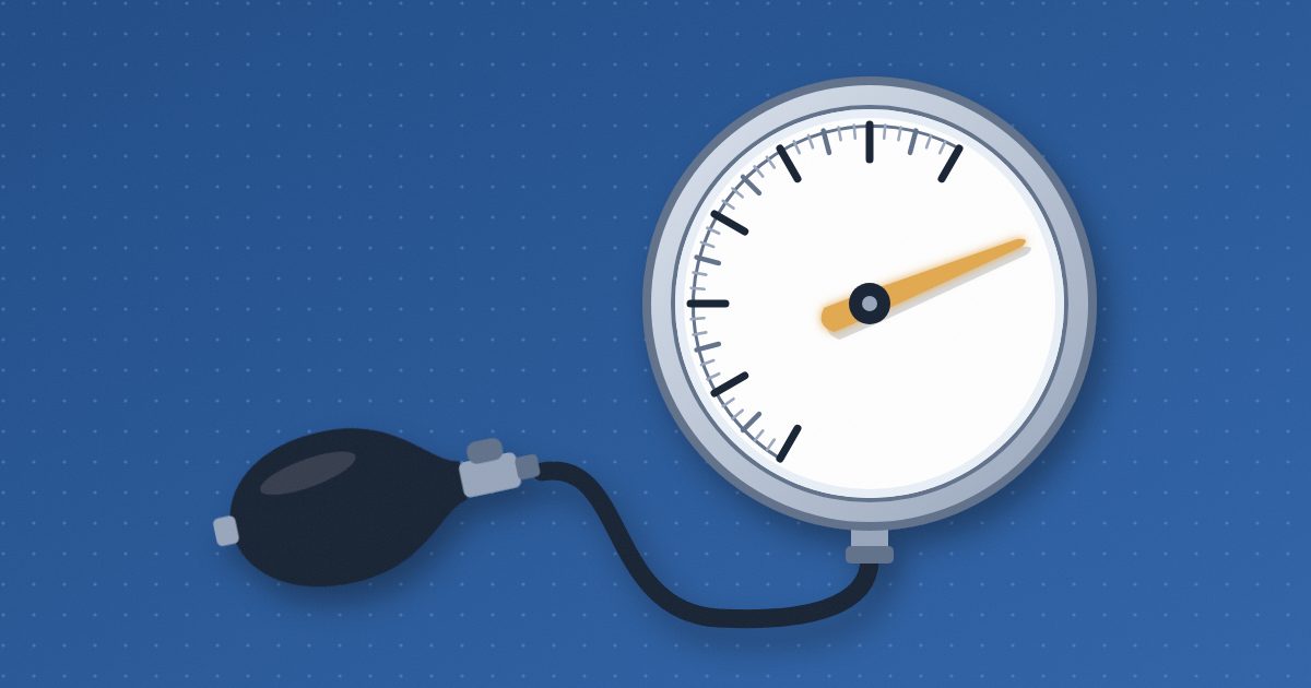 A blood-pressure gauge with its tube and bulb, its amber needle swung past the last tick mark into the unmarked part of the dial.