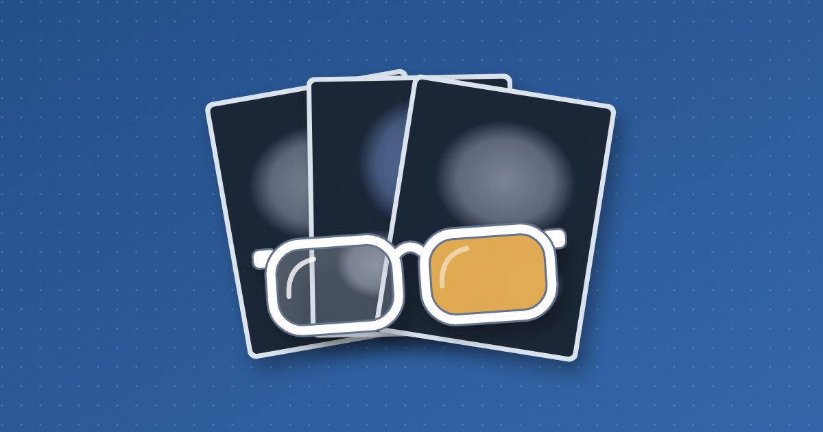 White-framed reading glasses rest on a fanned stack of three dark scan films with soft pale shapes; one lens is clear, the other amber.